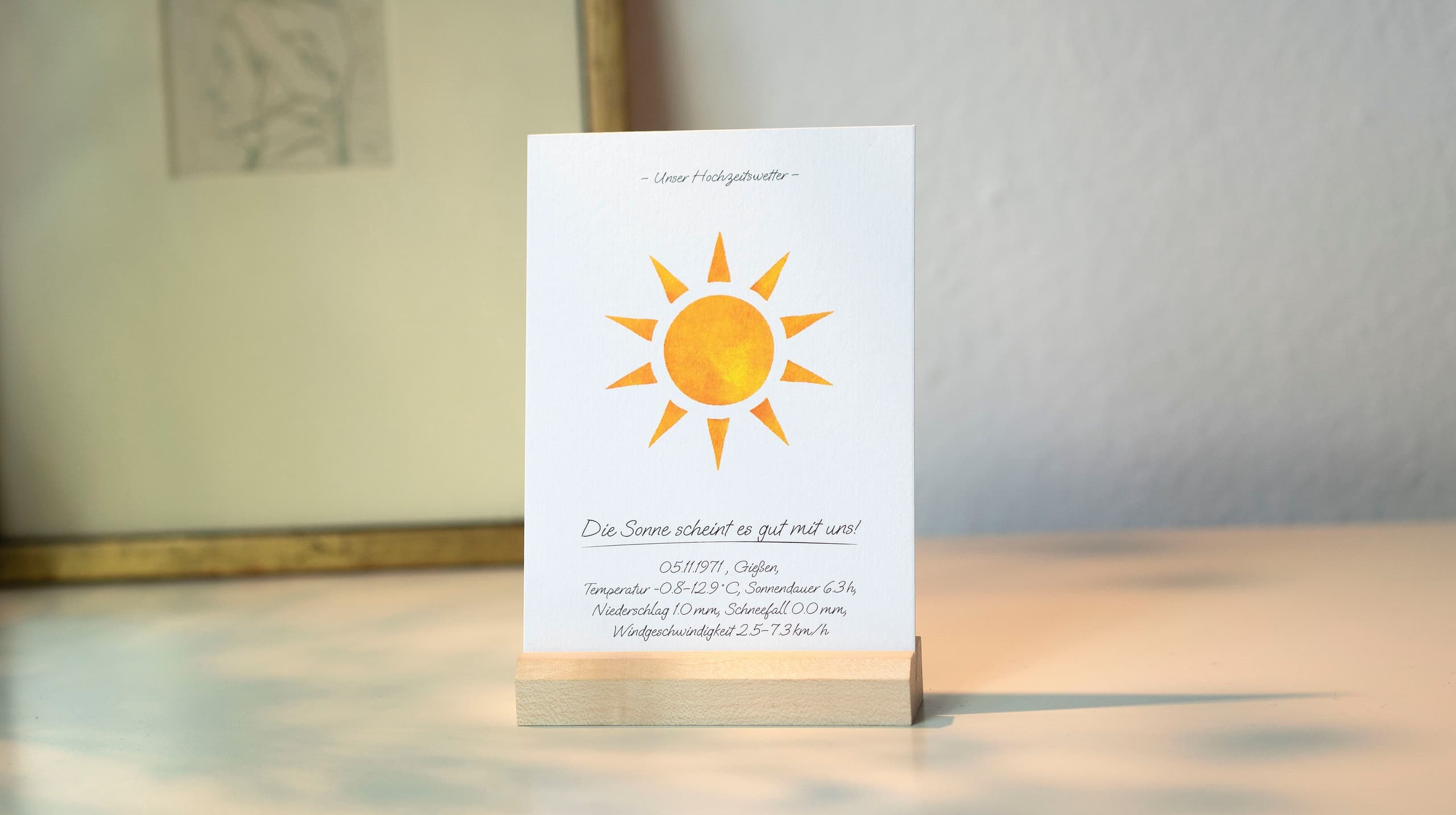 Product mood shot of a card in a wooden stand with a watercolour sun